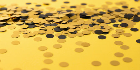 Golden confetti on yellow background. Festive concept. Copy space.の素材