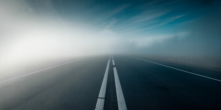 Empty asphalt road in the fog with blue sky background and copy spaceの素材