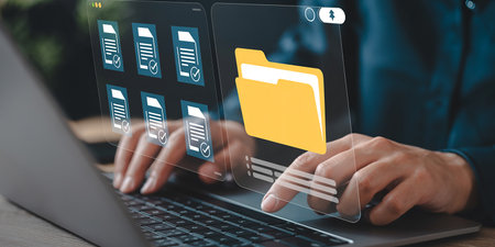 Businessman working on laptop with folder icon on screen. Business and technology concept.の素材