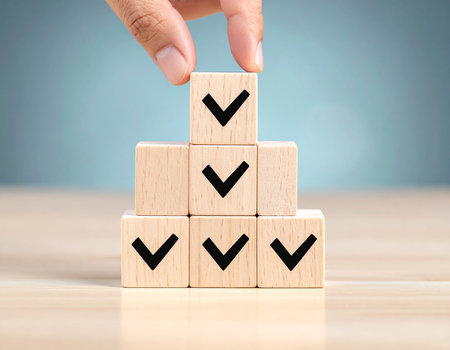 Businessman hand placing wooden cube block with check mark icon on topの素材