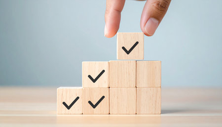 Hand of business man arranging wooden block stacking as step stair with check mark symbol, business success conceptの素材