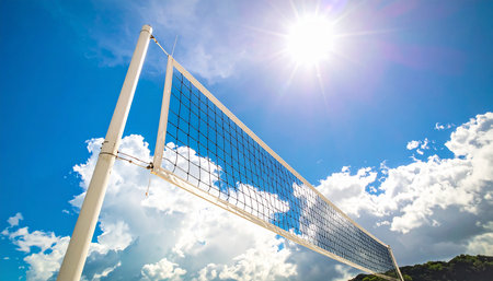 Volleyball net on blue sky with white clouds and sunbeamsの素材