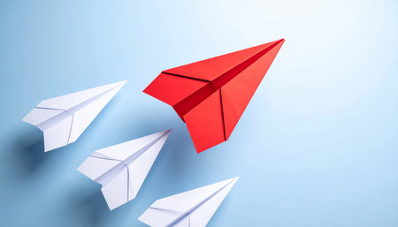 Leadership concept with red paper plane and white paper planes on blue backgroundの素材