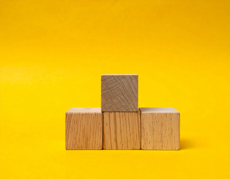 Wooden cubes on a yellow background. The concept of business growth.の素材