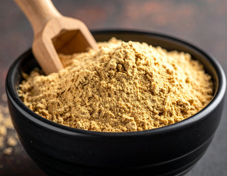 Curry powder in a black bowl and wooden scoop, selective focusの素材