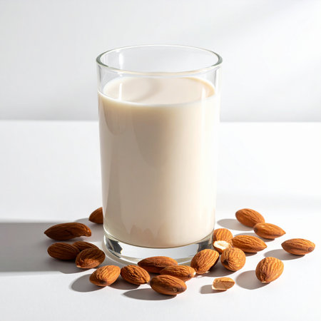 Almond milk in a glass with almonds on a white background.の素材