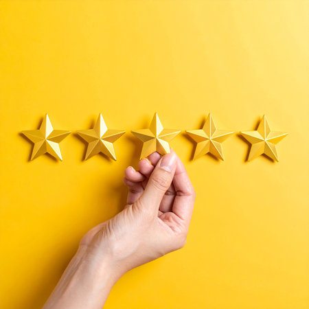 Female hand holding five star rating on yellow background. Top view with copy spaceの素材