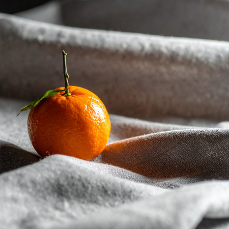 Fresh tangerine on a gray fabric background. Selective focus.の素材