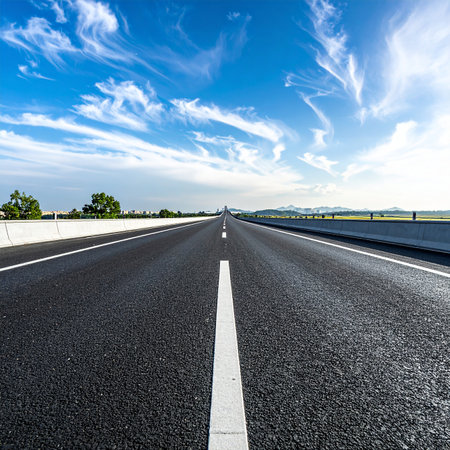 Asphalt road and blue sky with white clouds. Perspective view.の素材
