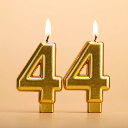Birthday candles with number forty four (44) on color backgroundの素材