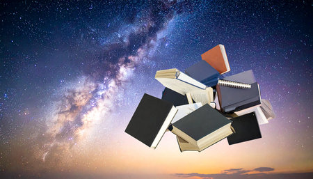 Pile of books flying in the night sky with milky wayの素材