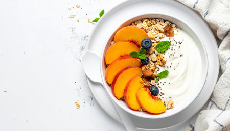 Healthy breakfast. Oatmeal with yogurt, berries and granola in bowl on white background, top viewの素材