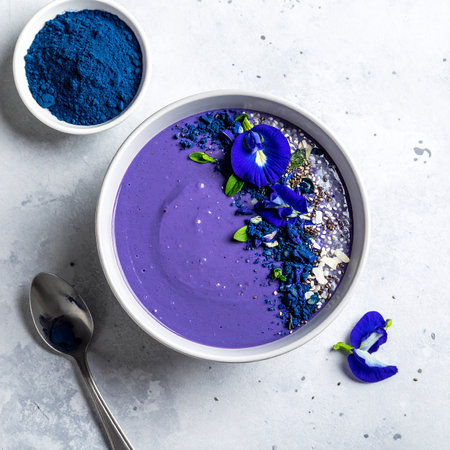 Blue spirulina smoothie bowl with butterfly pea flowers and blue spirulina powder. Healthy vegan food concept.の素材