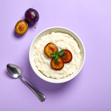 Rice porridge with plums in a bowl on a purple backgroundの素材