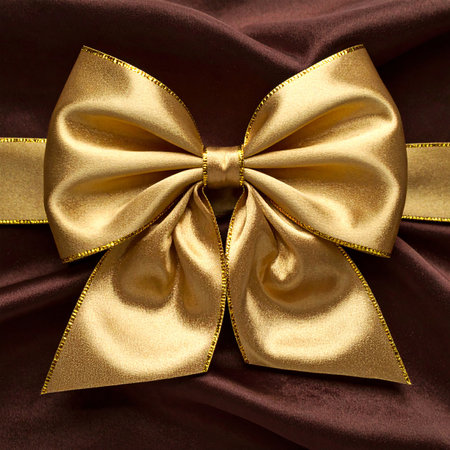 golden bow on satin background close up. Luxury giftの素材