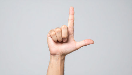 Man's hand showing middle finger isolated on gray background with copy spaceの素材
