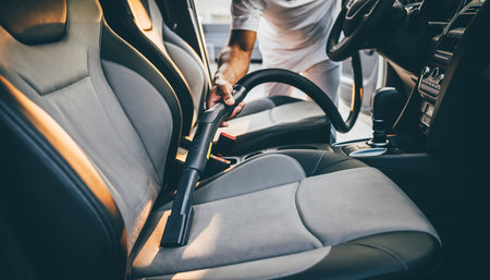 Man cleaning car interior with vacuum cleaner. Cleaning service concept.の素材