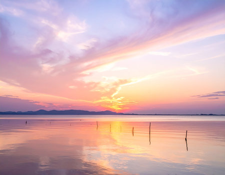 Calm lake at sunset with a colorful sky reflected on the water's surface. Clear details and vibrant colors en...の素材