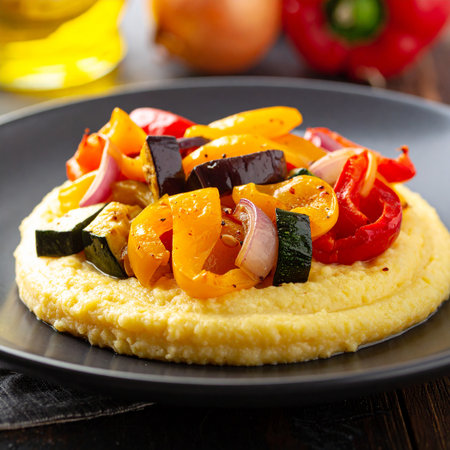Roasted vegetables atop creamy polenta on a dark plate, close-up view Clear details and vibrant colors enhanc...の素材