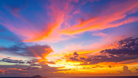 A fiery sunset sky with intense pink and orange clouds over a calm ocean horizon.の素材