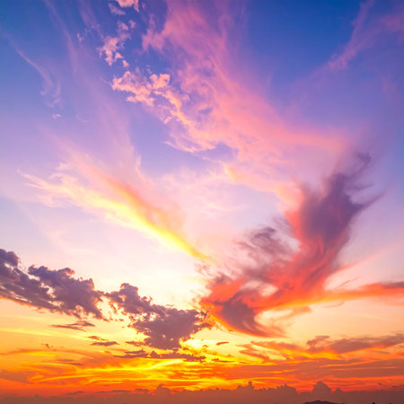 Wispy pink and orange clouds streak across a blue sky during a vibrant sunset. Clear details and vibrant colo...の素材