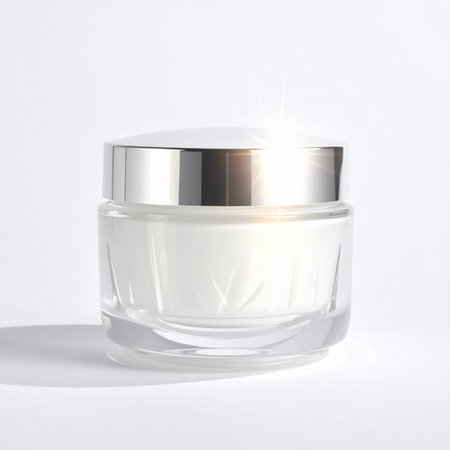 Glass jar of white cream with silver lid and sparkling light effects on white backgroundの素材