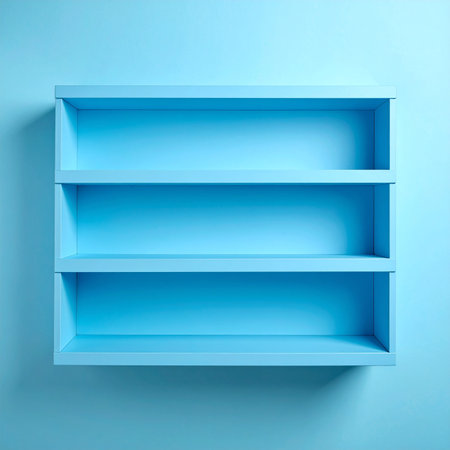 An empty light blue rectangular wall shelf with three tiers against a soft blue wall.の素材