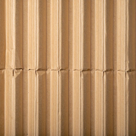 A full frame close-up of corrugated cardboard showing vertical fluting and distinct folded seams.の素材
