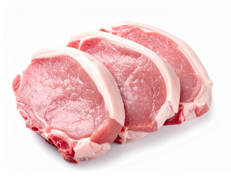 Three raw pork chops with bone and fat are isolated on a white background. Clear details and vibrant colors e...の素材