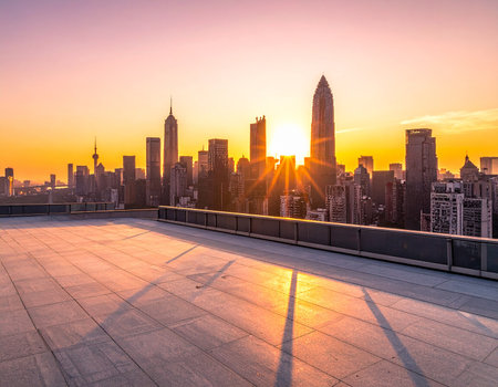 A city skyline at sunset viewed from a rooftop terrace with sunburst rays and shadows.の素材