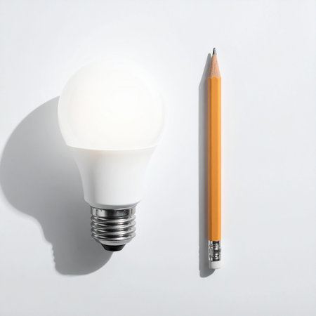Pencil and light bulb on white background, top view. Energy saving conceptの素材