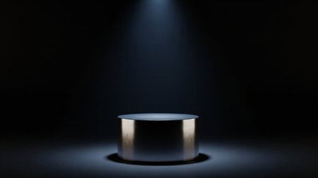 A polished silver cylindrical podium is illuminated by a single spotlight from above against a dark background.の素材
