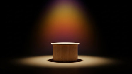 A round wooden pedestal is illuminated by a warm spotlight, casting a glow against a dark background with a colorful gradient.の素材