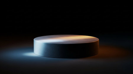 A textured circular platform sits on a dark stage, lit by a combination of warm and cool spotlights.の素材