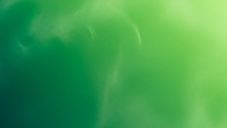 A soft green and yellow gradient background is overlaid with wispy white smoke or cloud-like formations, creating an ethereal and organic feel.の素材