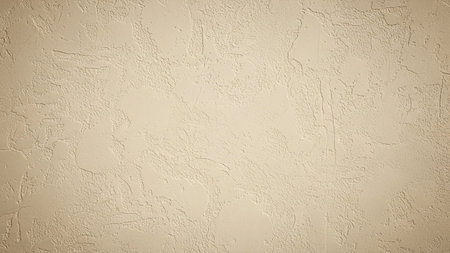 A close-up view of a textured beige stucco wall surface with subtle imperfections and a slightly uneven finish, providing a neutral backdrop.の素材