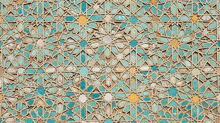 An intricate, aged mosaic tile pattern featuring turquoise and yellow stars with detailed geometric shapes and a weathered texture.の素材