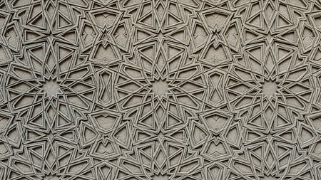 Close-up of a grey stone surface with an intricate, deeply carved geometric Islamic pattern featuring stars and polygons.の素材