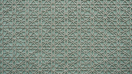 A detailed Islamic geometric pattern with a repeating star motif on an aged, textured green background.の素材