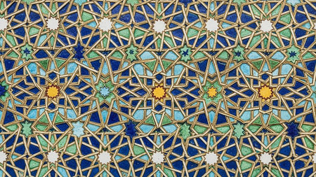 A vibrant mosaic tile pattern featuring intricate geometric stars in shades of blue, green, yellow, white, and gold, with a detailed repeating design.の素材