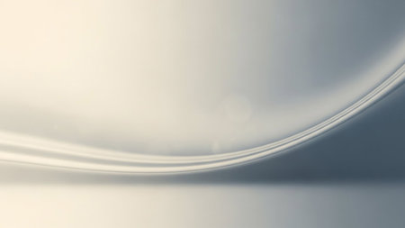 A soft white and gray abstract background with a gentle curve and a subtle light flare.の素材