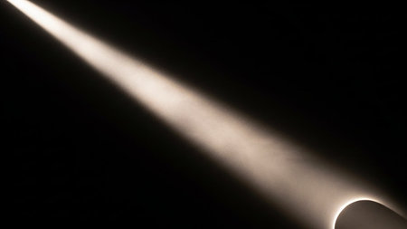 A sharp diagonal beam of light cuts through darkness, illuminating a subtle curved edge.の素材