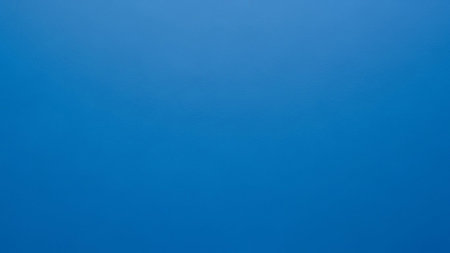 A solid deep blue gradient background with a very subtle, fine-grained texture visible.の素材