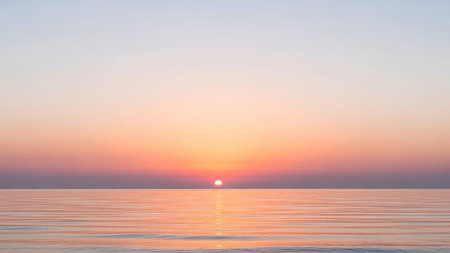 A tranquil ocean sunset with soft pink and orange hues painting the sky and reflecting on the gently rippling water.の素材