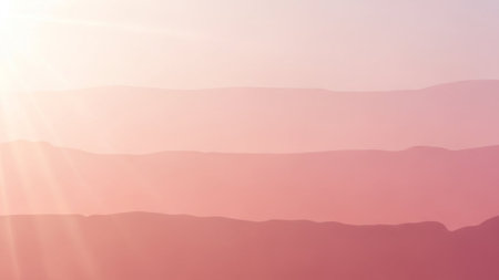 Soft pink mountain layers fade into a gradient sky with gentle sun rays emanating from the left.の素材