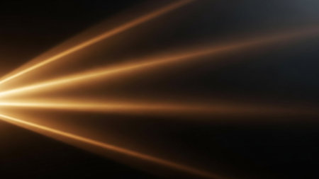 Golden light streaks radiating from a bright source against a dark background, creating a sense of energy and motion.の素材