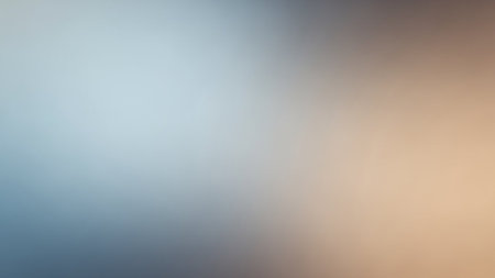 A soft, blurred gradient background with smooth transitions between cool blue and warm beige tones.の素材