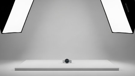 A wristwatch is displayed on a white platform under professional studio lighting with softboxes.の素材