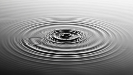 Concentric water ripples create a mesmerizing pattern of circles on a dark, still surface.の素材