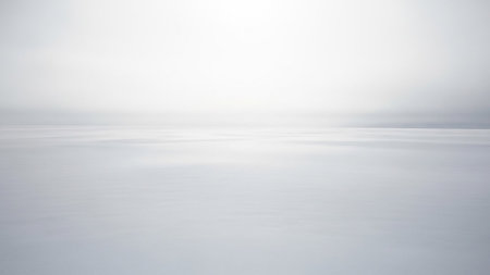 A minimalist abstract scene of a vast white snow-covered plain meeting a pale sky.の素材
